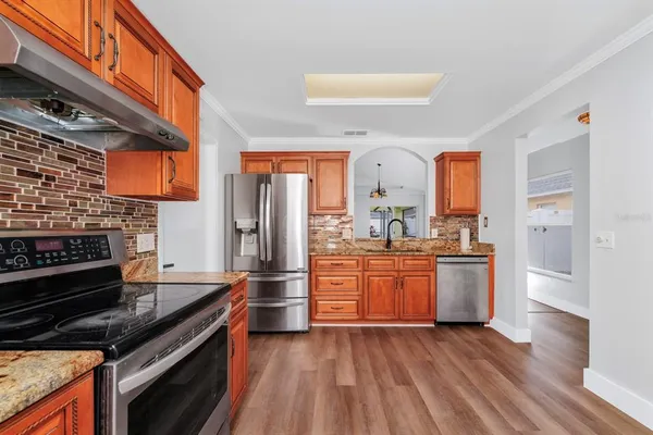 a kitchen with stainless steel appliances granite countertop a stove and a refrigerator