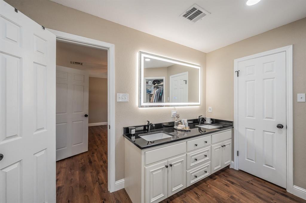 1325 North Katy Road Elm Mott, TX 76640 - Photo 12 of 30 a bathroom with a granite countertop sink and a mirror
