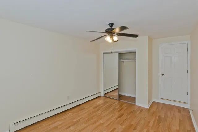 a view of room with wooden floor and ceiling fan