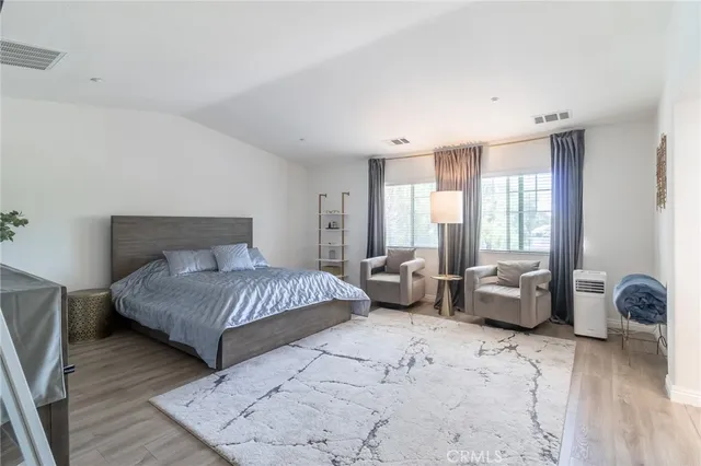 a bedroom with furniture and a large window