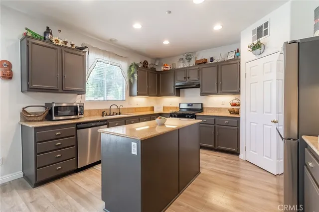 a kitchen with stainless steel appliances granite countertop a refrigerator stove and sink