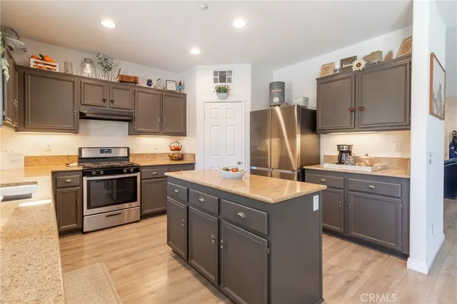 a kitchen with stainless steel appliances granite countertop a refrigerator stove and sink
