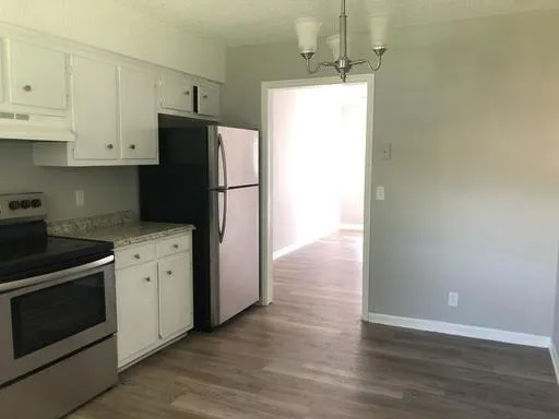 a kitchen with a refrigerator sink and cabinets