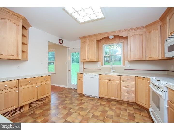 115 Brookside Road Newtown Square, PA 19073 - Photo 3 of 24 a kitchen with granite countertop a stove a sink and a microwave