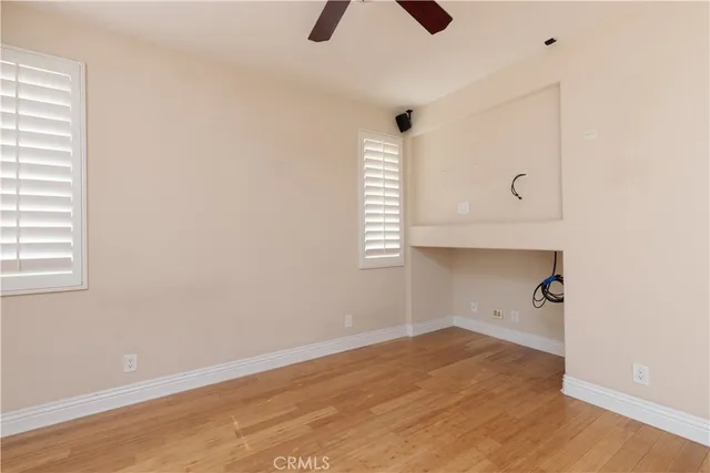 an empty room with ceiling fan and window