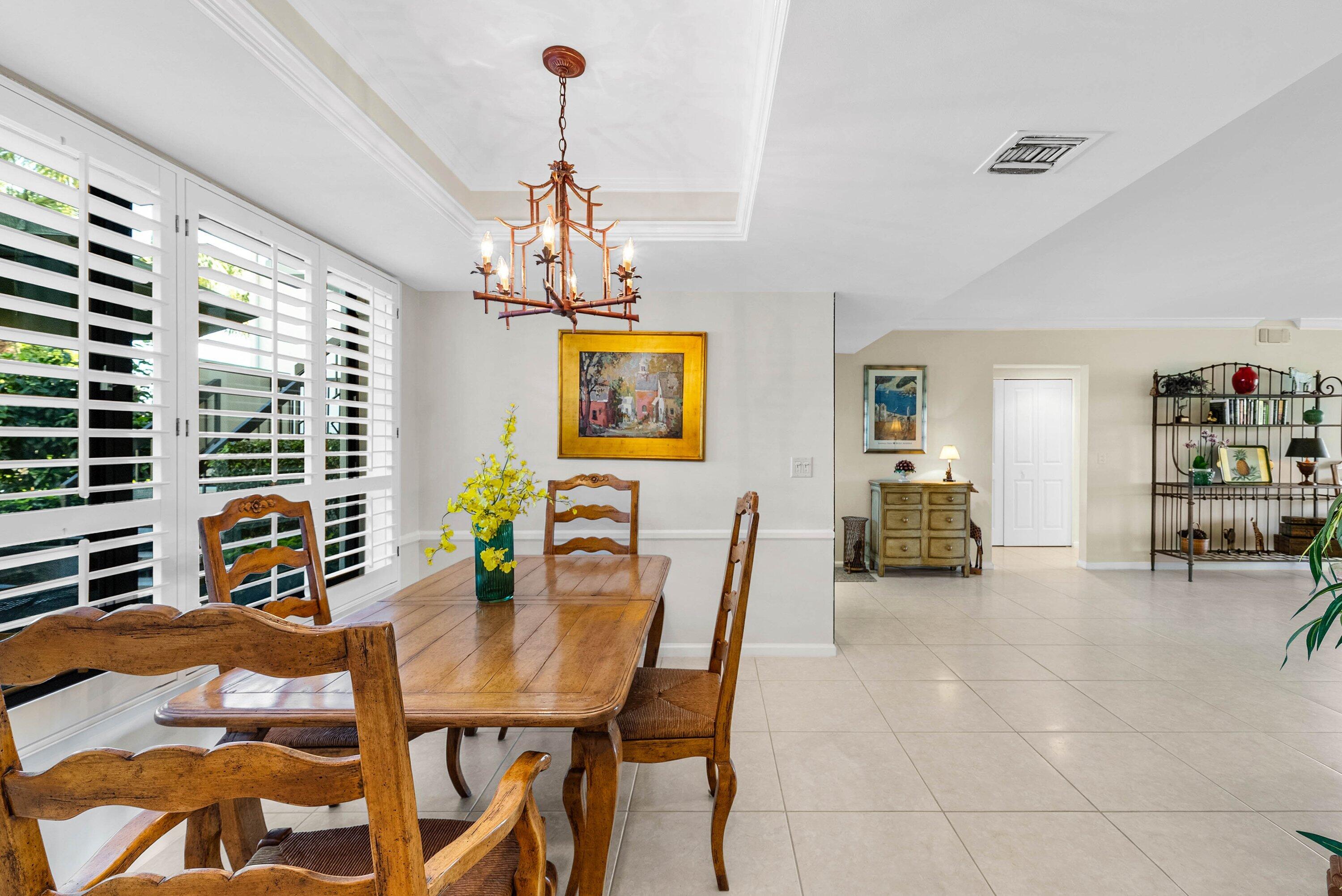 10865 Quail Covey Road, Unit AZALEA Boynton Beach, FL 33436 - Photo 16 of 55 a view of a dining room with furniture and a chandelier
