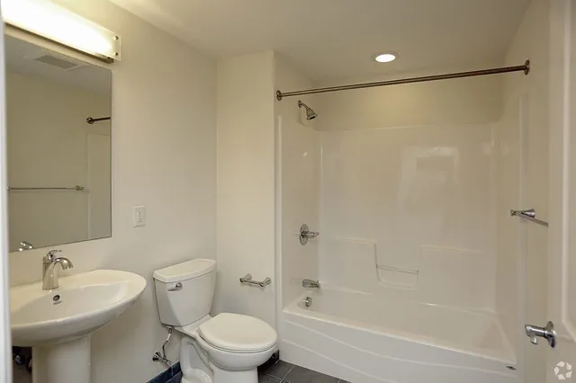 a bathroom with a sink mirror toilet and bathtub