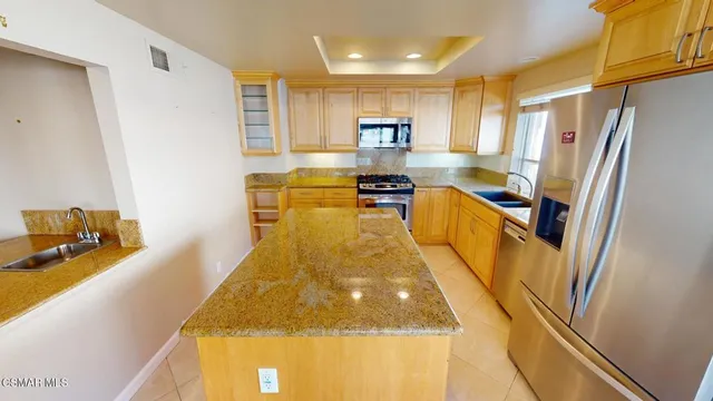 a kitchen with stainless steel appliances granite countertop a sink stove and cabinets