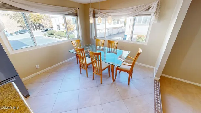 a dining room with furniture and a floor to ceiling window