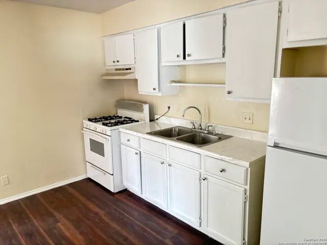 a kitchen with cabinets a stainless steel appliances and wooden floor