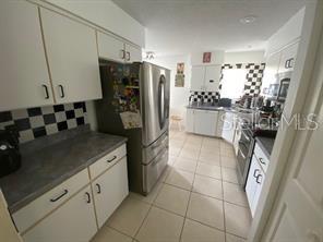 30 San Rafael Court Palm Coast, FL 32137 - Photo 19 of 32 a kitchen with a sink a refrigerator and cabinets