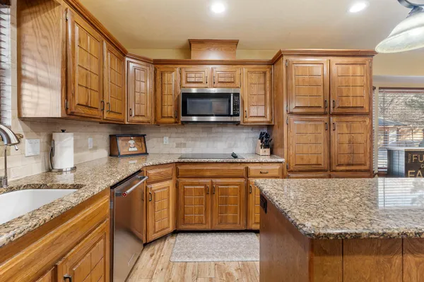a kitchen with granite countertop a sink and a stove top oven