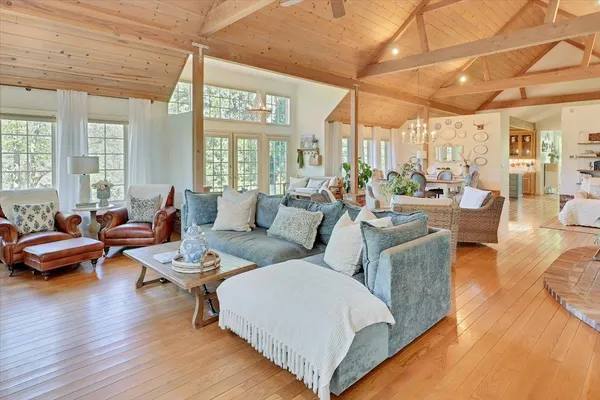 a living room with furniture a flat screen tv and wooden floor