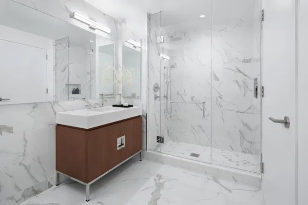 a bathroom with a sink mirror and shower