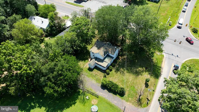 an aerial view of residential house with outdoor space and trees all around