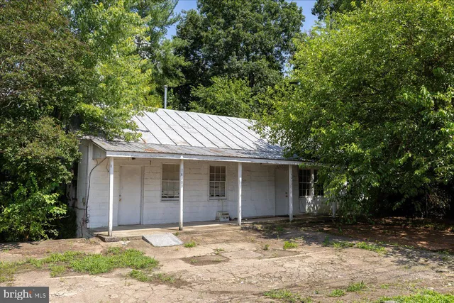 a front view of a house with a garden and tree