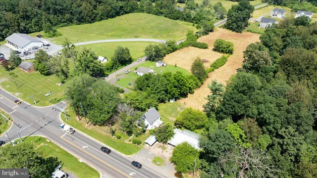 an aerial view of residential houses with outdoor space and trees all around
