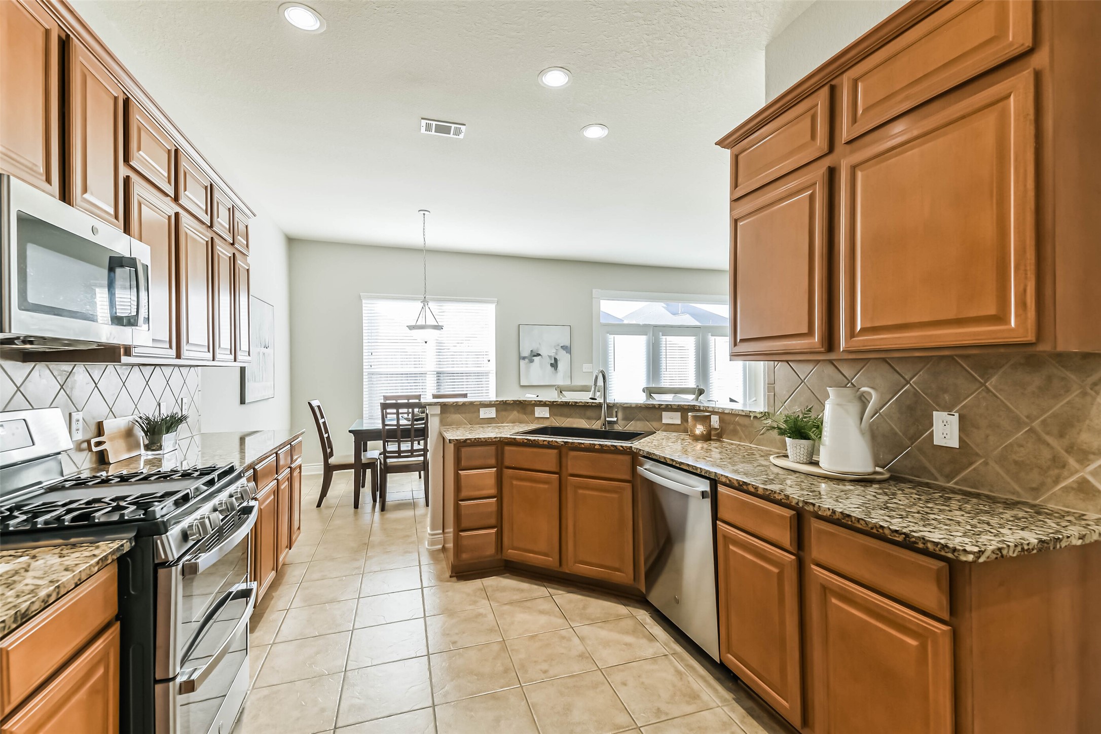 19022 Greenleaf Ridge Court Cypress, TX 77429 - Photo 18 of 47 a kitchen with stainless steel appliances granite countertop a stove top oven a sink dishwasher and cabinets with wooden floor