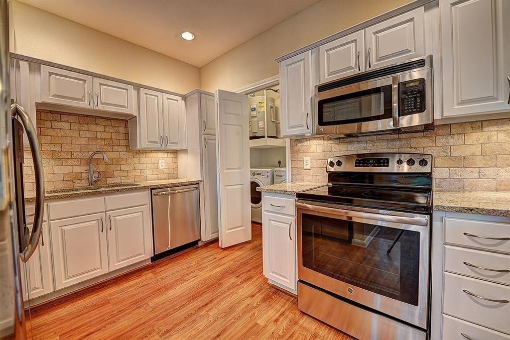 a kitchen with stainless steel appliances white cabinets a stove top oven and refrigerator