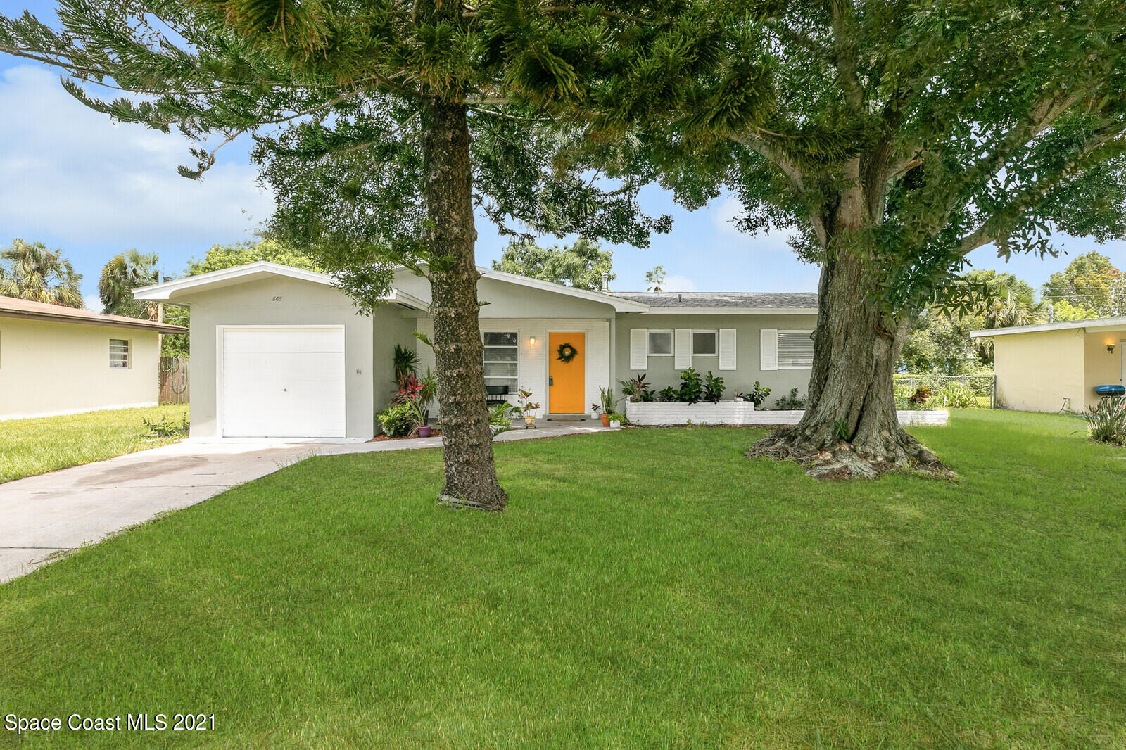 865 Osage Avenue Melbourne, FL 32935 - Photo 1 of 38 a front view of a house with a garden and yard