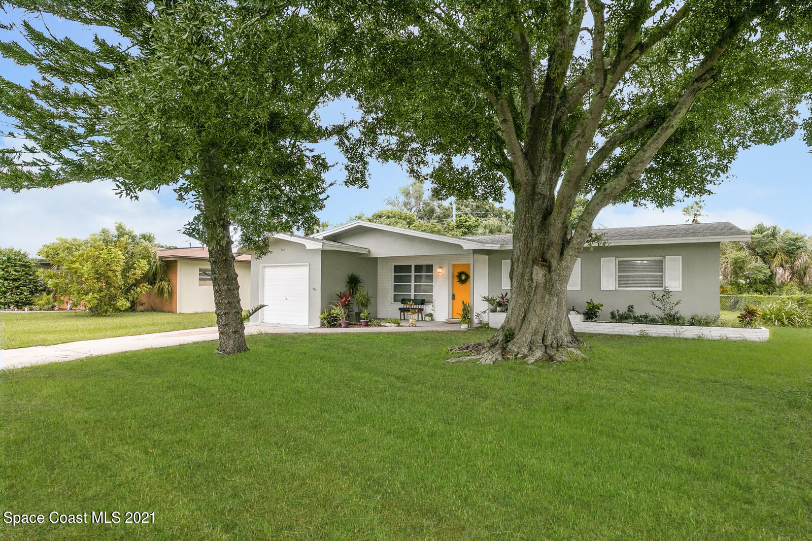 865 Osage Avenue Melbourne, FL 32935 - Photo 2 of 38 a front view of a house with a garden and trees