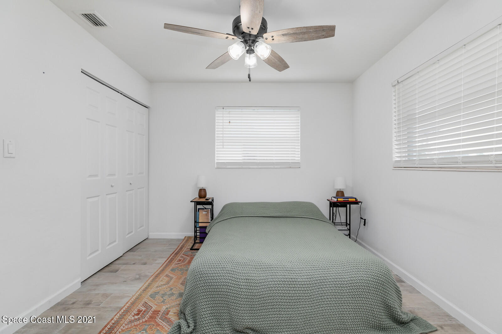 865 Osage Avenue Melbourne, FL 32935 - Photo 11 of 38 a bedroom with a bed and a chandelier