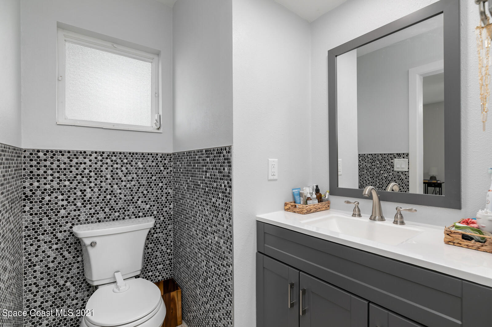 865 Osage Avenue Melbourne, FL 32935 - Photo 14 of 38 a bathroom with a toilet a sink and mirror