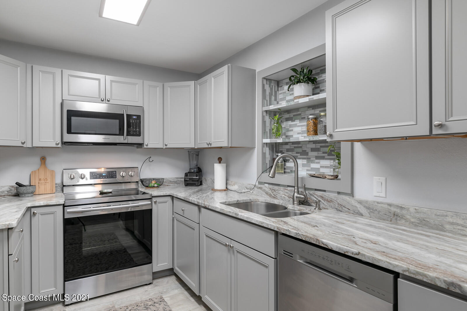 865 Osage Avenue Melbourne, FL 32935 - Photo 4 of 38 a kitchen with stainless steel appliances granite countertop white cabinets a sink and dishwasher