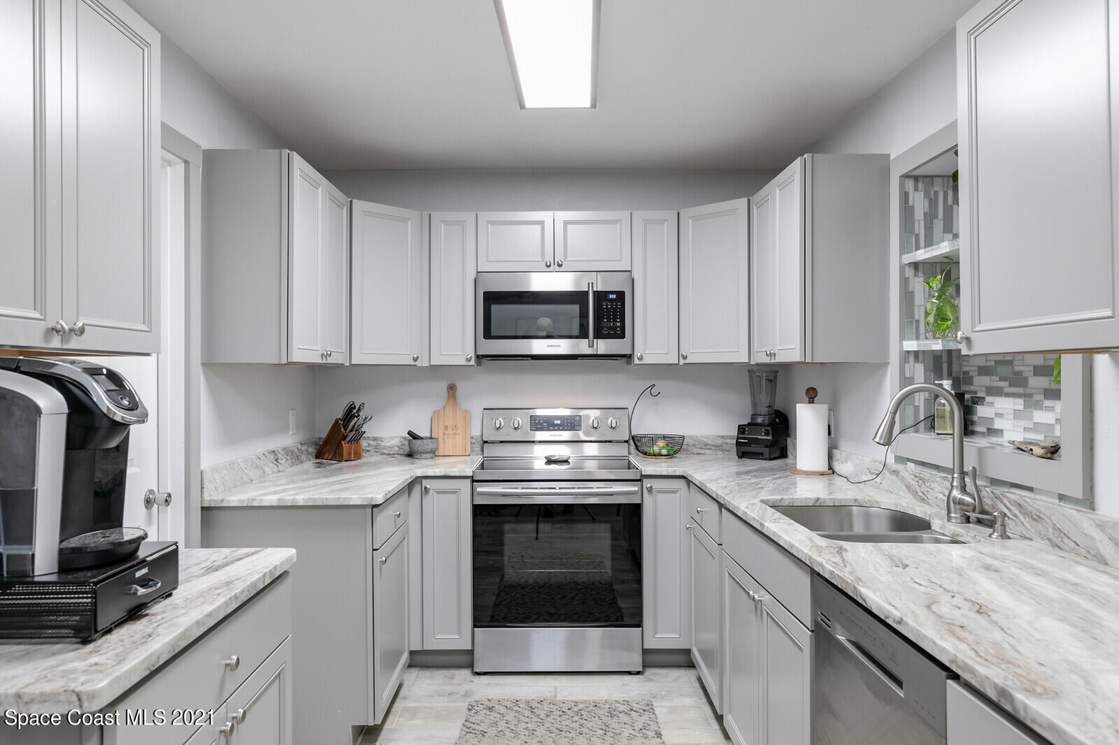 865 Osage Avenue Melbourne, FL 32935 - Photo 5 of 38 a kitchen with granite countertop a stove sink and cabinets