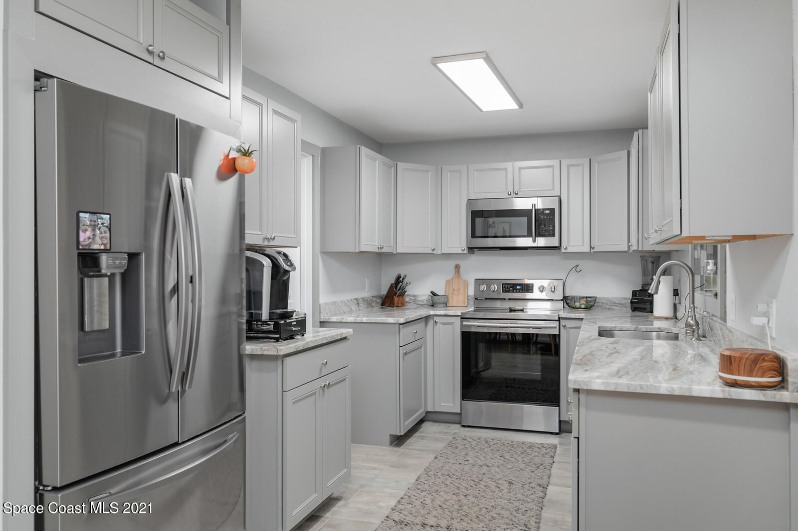865 Osage Avenue Melbourne, FL 32935 - Photo 6 of 38 a kitchen with stainless steel appliances granite countertop a refrigerator stove and sink