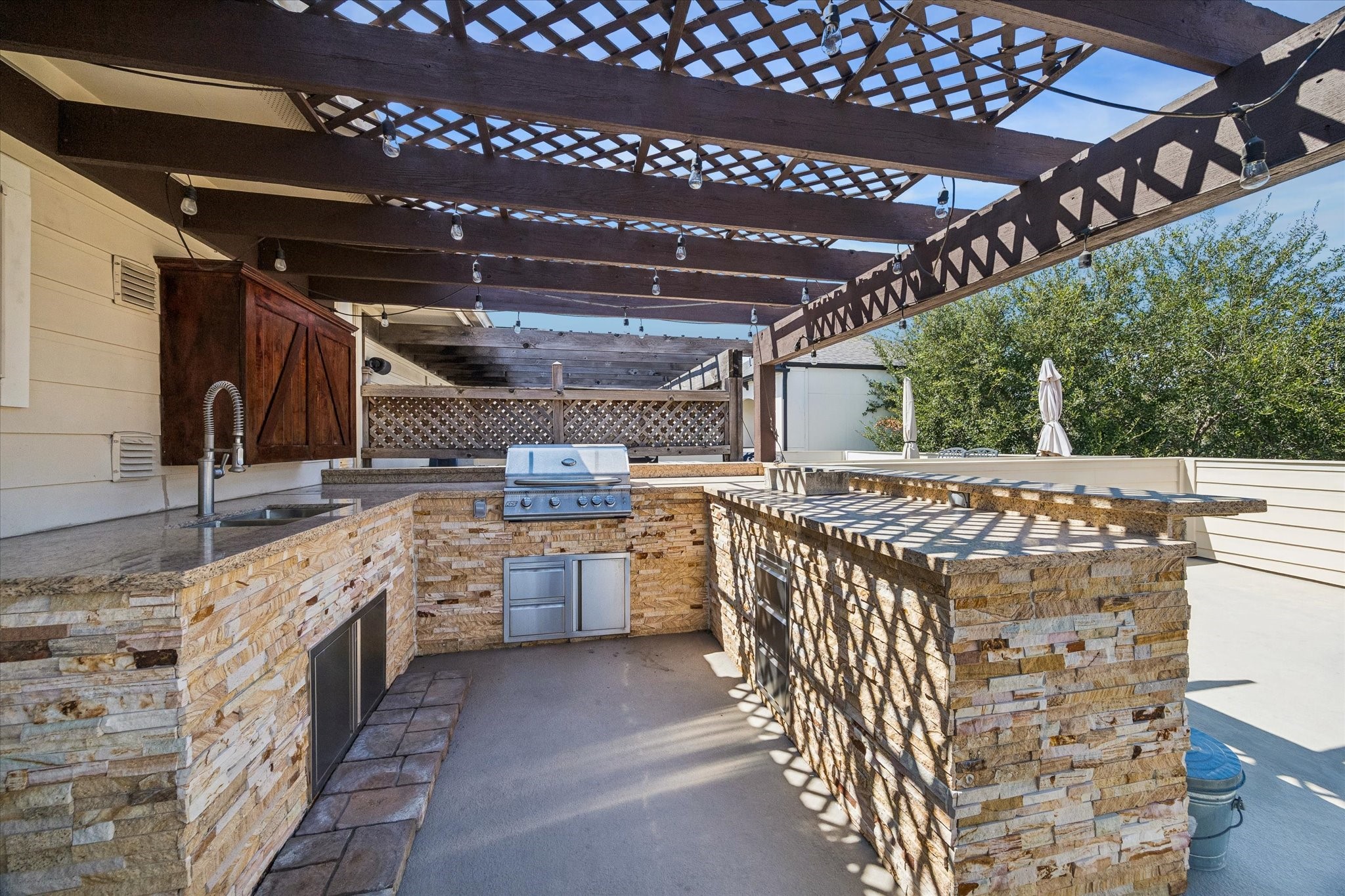 5334 Inker Street Houston, TX 77007 - Photo 28 of 39 Stunning outdoor kitchen featuring a built-in gas grill, custom cabinetry, sink, and a spacious bar area perfect for entertaining guests.
