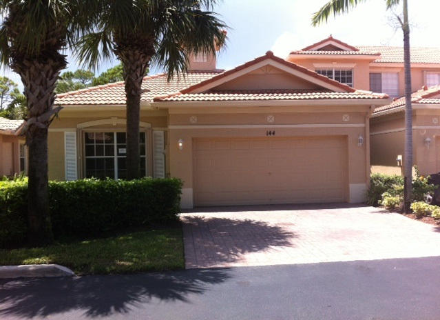 144 Coconut Key Lane Delray Beach, FL 33484 - Photo 1 of 16 a front view of a house with a yard and garage
