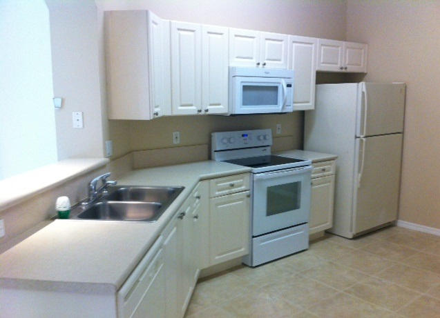 144 Coconut Key Lane Delray Beach, FL 33484 - Photo 7 of 16 a kitchen with white cabinets and white stainless steel appliances