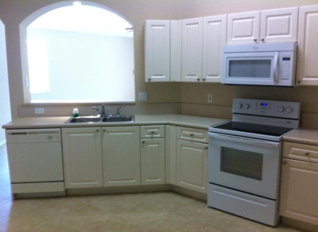 144 Coconut Key Lane Delray Beach, FL 33484 - Photo 8 of 16 a kitchen with granite countertop white cabinets and white appliances