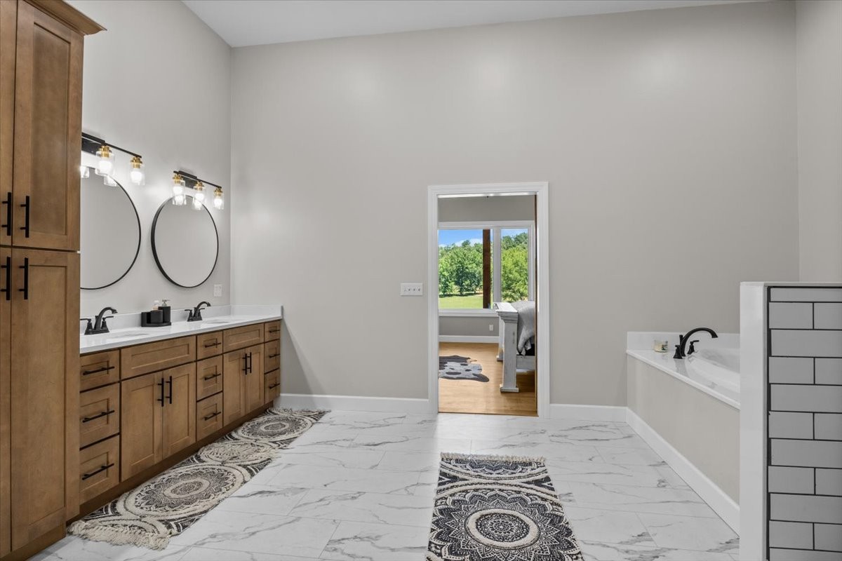 1489 Utley Road Camden, TN 38320 - Photo 18 of 60 a spacious bathroom with a granite countertop sink mirror and bathtub