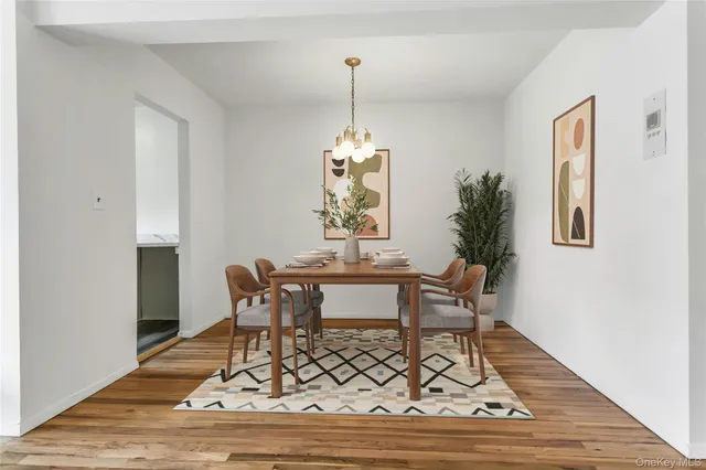 a dining room with wooden floor a chandelier a wooden table and chairs