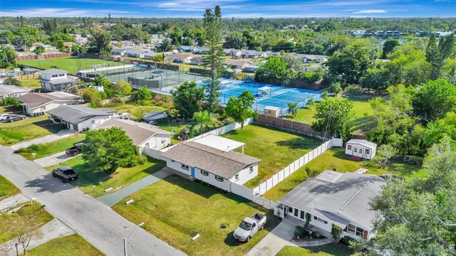 an aerial view of a house with a garden and lake view