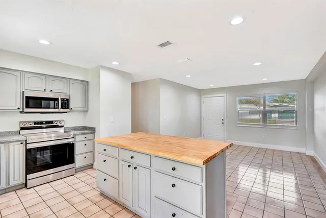 a kitchen with a stove sink and cabinets