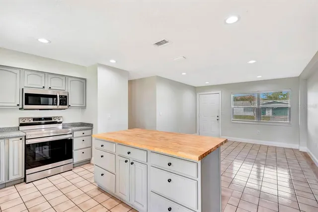a kitchen with a stove sink and cabinets