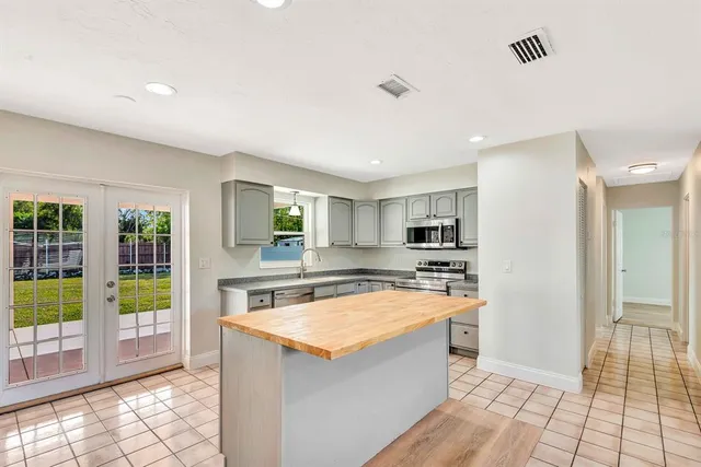 a kitchen with stainless steel appliances granite countertop a refrigerator and a sink