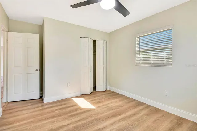 a view of a livingroom with wooden floor and a ceiling fan