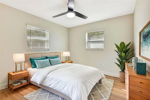 a bedroom with a bed and a potted plant on the dresser