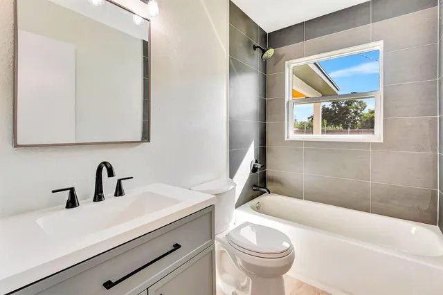 a bathroom with a sink a mirror a toilet and a bathtub