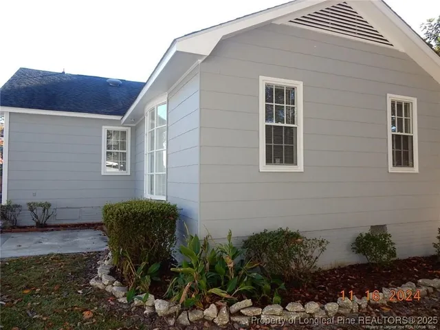 a view of backyard with a table and chair and potted plants