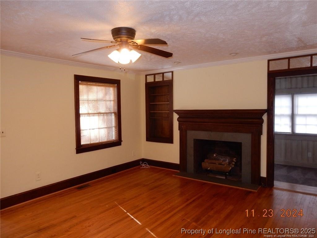 708 Rush Road Fayetteville, NC 28305 - Photo 6 of 17 a view of an empty room with wooden floor fireplace and a window