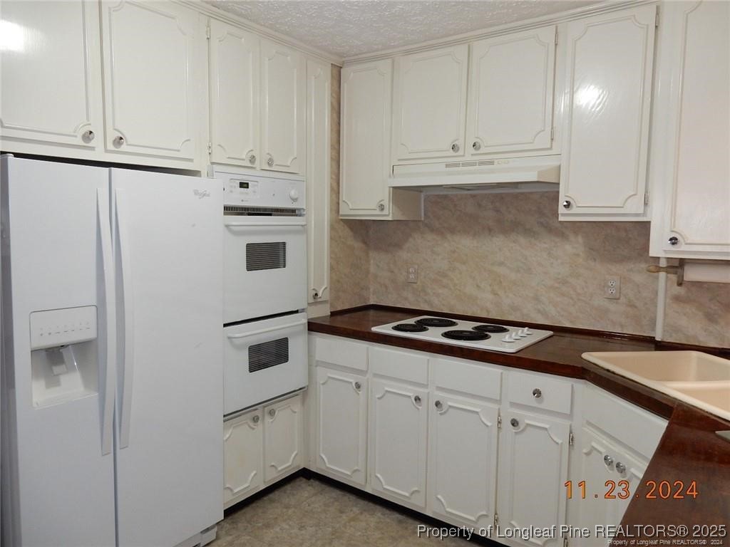 708 Rush Road Fayetteville, NC 28305 - Photo 10 of 17 a kitchen with granite countertop white cabinets and white appliances