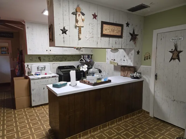 a kitchen with sink cabinets and stove top oven