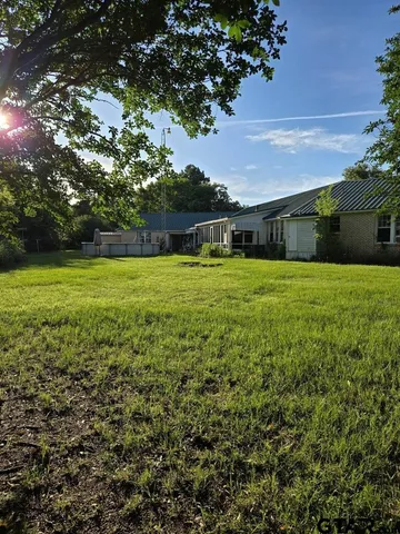 a view of a big yard with a house in the background