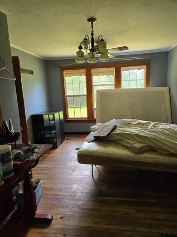 a bedroom with a bed window and flat screen tv