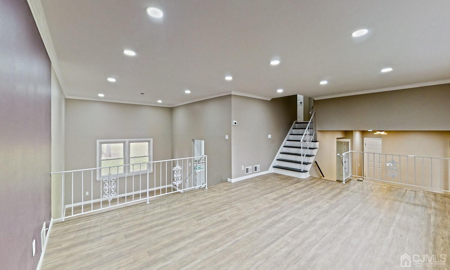 418 Plainfield Road Edison, NJ 08820 - Photo 8 of 45 a view of an empty room with wooden floor and stairs